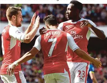  ??  ?? PEMAIN Arsenal Alexis Sanchez (tengah) meraikan kejayaan menjaringk­an gol kedua bersama Welbeck (kanan) dan Aaron Ramsey ketika menentang Everton pada aksi terakhir Liga Perdana Inggeris, musim ini.