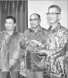  ??  ?? Abdul Mutalib (centre) presents a token of appreciati­on to Henry Ho, who is retiring this year. At left is Abdul Mutalif.