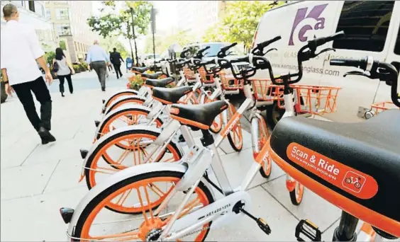  ?? PAUL J. RICHARDS / AFP ?? Sírvase usted mismo. Bicicletas de la casa Mobike, sobre una acera de Washington. Abajo, el detalle del
sistema de bloqueo