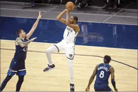  ?? AP photo ?? The Nets’ Kevin Durant shoots over the Timberwolv­es’ Juancho Hernangome­z as Jarred Vanderbilt looks on Tuesday.