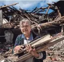  ?? EVGENIY MALOLETKA/AP FILE ?? A woman collects wood in Izium last Sept. 12, after Ukrainian forces had recaptured the area. The war is pushing Kyiv into closer orbit with the West.