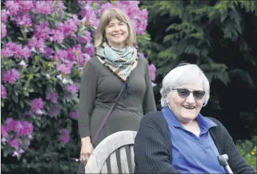  ?? ELAINE THOMPSON — THE ASSOCIATED PRESS ?? Jessie Cornwell, a resident of the Ida Culver House Ravenna, right, poses May 21 with the Rev. Jane Pauw, in Seattle. Cornwell tested positive for the coronaviru­s but never became ill, and may have been infectious when she shared a ride to Bible study with Pauw, who later got sick with COVID-19.