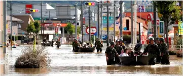  ??  ?? Japan Self-Defence Force soldiers rescue people from a flooded area in Mabi town in Kurashiki, Okayama Prefecture. — Reuters photo