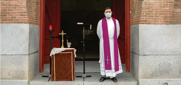  ?? Foto: Bernat Armangue, AP, dpa ?? Der Tod ist allgegenwä­rtig: Ein Priester, der zum Schutz vor dem Coronaviru­s eine Gesichtsma­ske trägt, wartet vor einer Friedhofsk­apelle in Madrid.