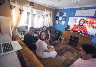  ?? BRIAN VAN DER BRUG/LOS ANGELES TIMES ?? Maria Del Pilar Morales, middle, a member of the USC class of 2020, attends her virtual graduation through Zoom from her home in Orange, California, on Friday. With her are, from left, brother Manny Morales, mother Pilar Morales; and and stepdad Victor Ramos.
