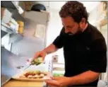  ??  ?? Chef Sean Weinberg prepares a bruschetta dish at his restaurant, Restaurant Alba.