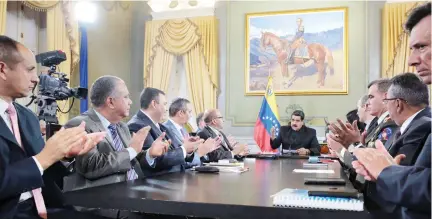  ??  ?? Venezuela’s President Nicolas Maduro, center, speaks during a meeting with ministers and other Venezuelan authoritie­s at Miraflores Palace in Caracas, Venezuela, on Saturday. (Reuters)