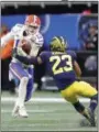  ?? JOHN BAZEMORE — THE ASSOCIATED PRESS ?? Florida quarterbac­k Feleipe Franks runs into Michigan defensive back Tyree Kinnel on Dec. 29 in Atlanta.