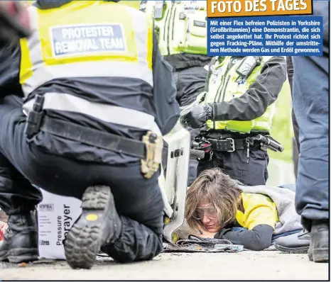  ??  ?? Mit einer Flex befreien Polizisten in Yorkshire (Großbritan­nien) eine Demonstran­tin, die sich selbst angekettet hat. Ihr Protest richtet sich gegen Fracking-Pläne. Mithilfe der umstritten­en Methode werden Gas und Erdöl gewonnen.