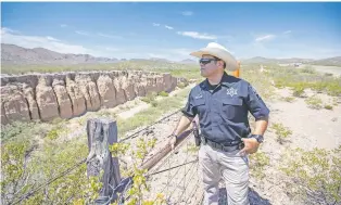  ?? IVAN PIERRE AGUIRRE/NEW YORK TIMES ?? Sheriff Oscar Carrillo of Culberson County surveys the desert landscape near Interstate 10 in Van Horn, Texas. After working in oil fields, Carrillo eyed the stability of law enforcemen­t or funeral work. As a border sheriff, he is doing both.