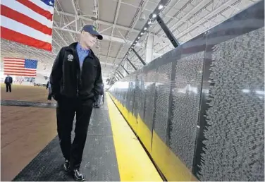  ?? CHRIS O’MEARA/ASSOCIATED PRESS ?? Florida Gov. Rick Scott looks at the names on a replica of the Vietnam Veterans Memorial wall at the Florida State Fair in Tampa on Thursday. It was there that Scott briefly acknowledg­ed he mishandled the ouster of Gerald Bailey.