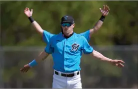 ??  ?? The Associated Press
Miami Marlins outfielder J.J. Bleday stretches in front of a teammate during spring training baseball practice Friday in Jupiter, Fla.