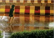  ?? Photo by Dhes Handumon ?? NOVEMBER RAIN: A woman walks in rain at the Discovery Gardens in Dubai on Sunday. —