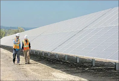  ?? AP/RICH PEDRONCELL­I ?? Workers inspect panels at Pacific Gas and Electric’s solar plant in Dixon, Calif., in August. Cheap imports have led to a boom in the U.S. solar industry.