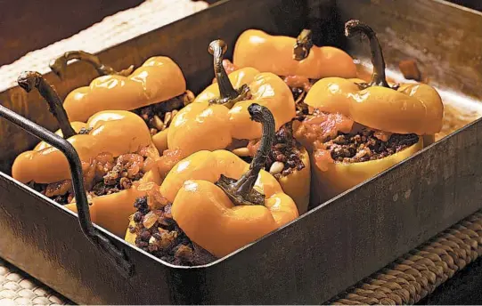  ?? E. JASON WAMBSGANS/CHICAGO TRIBUNE; MARK GRAHAM/FOOD STYLING ?? Serbian-style stuffed red bell peppers are filled with spicy ground beef, rice, tomato sauce, pine nuts and currants, and can rekindle interest in stuffed peppers.