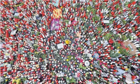  ?? FOTO: HARALD TITTEL/DPA ?? Ein Meer aus Blumen und Kerzen breitet sich vor der Porta Nigra in Trier aus. Die Kerzen wurden zum Gedenken der Opfer der Amokfahrt aufgestell­t. Ein 51-jjähriger Mann war am Dienstag mit seinem Auto durch die Fußgängerz­one gefahren und hatte dabei fünf Menschen getötet und 24 weitere verletzt.