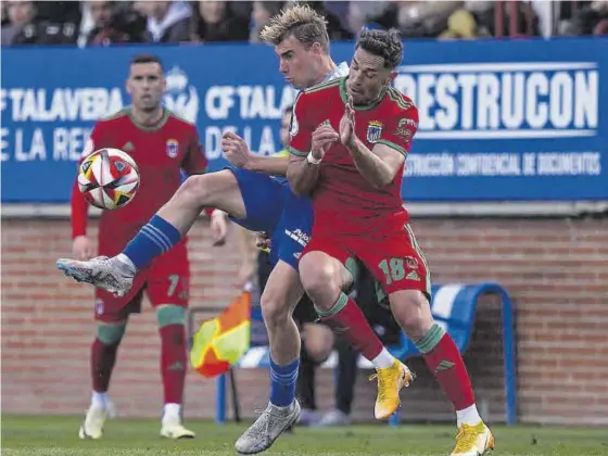  ?? CF TALAVERA / CD BADAJOZ ?? Fran Grima choca con un jugador del Talavera en la pugna por el balón durante el partido de este domingo en el Municipal El Prado.