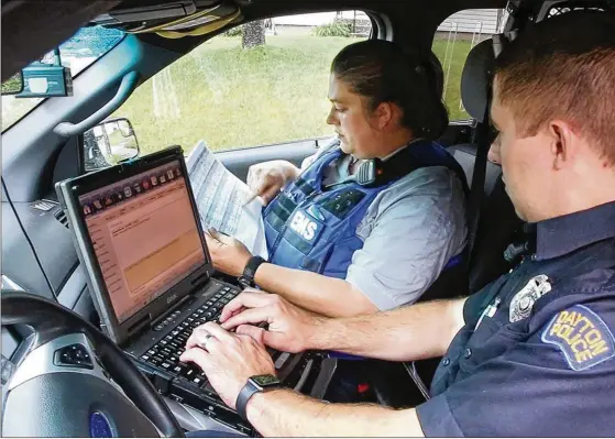  ?? TY GREENLEES / STAFF ?? Amy Dunkin (left), an EMT and addiction resource liaison with the Dayton Fire Department, and Dayton Police Addiction Liaison Officer Jason Olson map out their day connecting with opioid addicts to assist them with finding treatment. Dunkin believes the interventi­on is having an impact. “It was frustratin­g to give Narcan over and over again to that same person without there ever being anything else past that. Now I feel like we’re actually helping people,” she said.