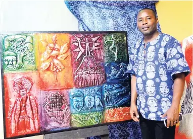  ??  ?? Nigerian cultural diplomat Alao Luqman stands beside artwork done by students he had taught in workshops run by the Jamaica Business Developmen­t Corporatio­n.