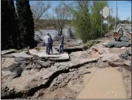  ?? (AP/Carlos Osorio) ?? Bob Yahrmarkt (right) stands in his water-damaged driveway Wednesday in Edenville, Mich.