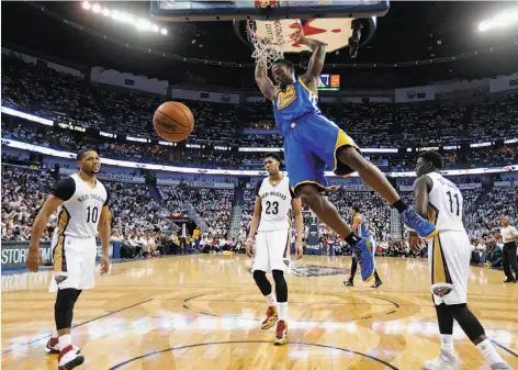  ?? Gerald Herbert / Associated Press ?? Warriors forward Harrison Barnes, who had six points and eight rebounds, dunks over three Pelicans in the second half.