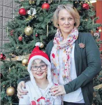  ?? KATHERINE HUNT/THE GUARDIAN ?? Nancy Fullarton and her eight-year-old daughter Sophie celebrate during the P.E.I. Military Family Resource Centre’s Christmas party at the Murchison Centre Sunday. The party was a chance for military members, veterans, RCMP and their families to share in some festive joy.