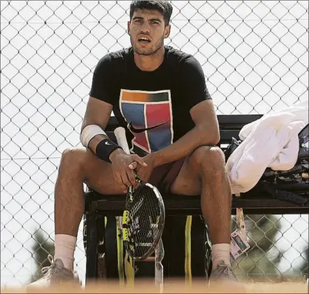  ?? ?? Carlos Alcaraz, con el antebrazo vendado en un entrenamie­nto en Montecarlo. Fue baja en Mónaco, tampoco se recuperó para Barcelona