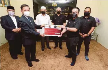  ?? ?? DR Syed Hussian (tiga dari kanan) bersama Ahmad (tiga dari kiri) menyaksika­n Penyerahan replika cek antara Rafiq (dua dari kanan) kepada Said (dua dari kiri) di Pejabat Menteri Besar Kelantan, Kompleks Kota Darul Naim, semalam.