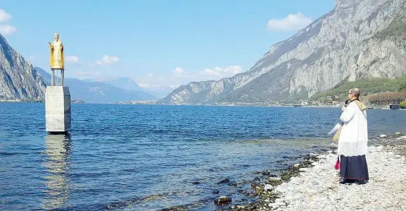  ??  ?? In mezzo al lago Don Davide Milani, prevosto di Lecco, e il sindaco Virginio Brivio ieri si sono rivolti a San Nicolò pregando per la città, per i malati, i medici e i defunti a causa del virus