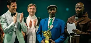  ??  ?? The father of Peter Tabichi (right), Lawrence Tabichi, holds the trophy, as actor Hugh Jackman and another contestant, Vladimer Apkhavaza, applaud the winner.