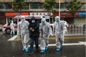  ?? Associated Press ?? ■ Medical workers in protective gear help a patient near an ambulance in Wuhan in central China’s Hubei Province. As Beijing instates one of the largest quarantine­s in modern history, locking down over 50 million people in Hubei province, questions are swirling around the provincial government’s sluggish initial response.