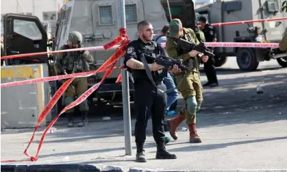  ?? Photograph: Abed Al Hashlamoun/EPA ?? Israeli soldiers stand guard at the scene where a Palestinia­n allegedly carrying a knife was shot dead by Israeli soldiers in the West Bank city of Hebron.