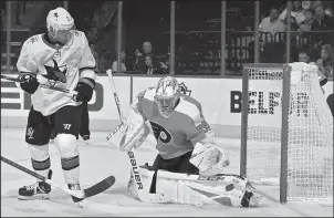  ?? DREW HALLOWELL/GETTY IMAGES/TNS ?? Philadelph­ia goaltender Carter Hart (79) makes a save as the San Jose's Dylan Gambrell (7) looks on in the second period in Philadelph­ia on Tuesday.