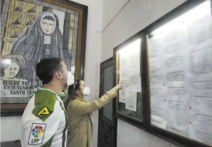  ?? A.J. GONZÁLEZ ?? Unos padres consultaba­n ayer la lista de admitidos en el colegio Santa Victoria.