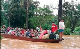  ?? ATTAPeu TV VIA AP ?? In this Tuesday photo, people on a boat are evacuated in the floodwater­s from a collapsed dam in southeaste­rn Laos.