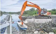  ?? AFP ?? Workers are seen clearing mounds of floating plastic waste on the outskirts of Kuala Lumpur late last year.