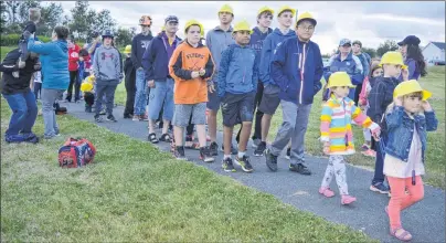  ?? CHRISTIAN ROACH/CAPE BRETON POST ?? Dozens of children wore plastic “miners’” hats, shone lights and laid roses at the monument in Colliery Lands Park on Tuesday. The children were part of the 100-year ceremony to remember the disaster in No. 12 Colliery in New Waterford that took the lives of 65 miners.