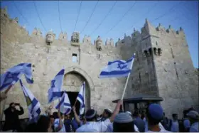  ?? ARIEL SCHALIT — THE ASSOCIATED PRESS ?? Israelis wave national flags outside the Old City’s Damascus Gate, in Jerusalem, Sunday. Israel is marking the 51st anniversar­y of its capture of east Jerusalem in the 1967 Middle East war.