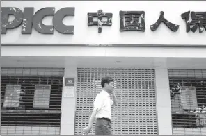  ?? ZHEN HUAI / FOR CHINA DAILY ?? A man walks past a PICC outlet in Nanjing, capital of Jiangsu province.