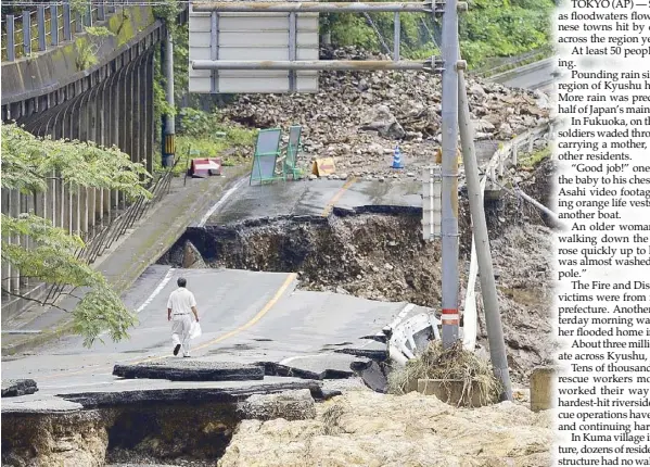  ?? AP ?? A man walks on heavily damaged road following heavy rain in Kumamura, Kumamoto prefecture, southern Japan on Monday. Rescue operations continued and rain threatened wider areas of the main island of Kyushu.