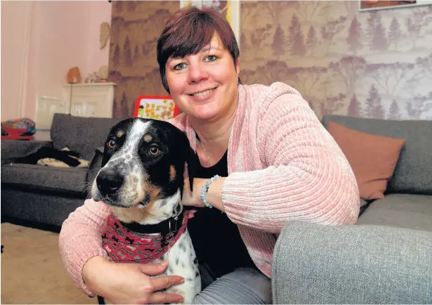  ?? RICHARD WILLIAMS ?? Lindsey Thomas with her dog Hugo, who started a fire at their home on New Year’s Eve by turning on the cooker