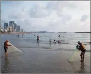  ?? (AP/Oded Balilty) ?? Two Israelis prepare to throw their fishing nets into the Mediterran­ean Sea on Aug. 31 on Tel Aviv’s beach.