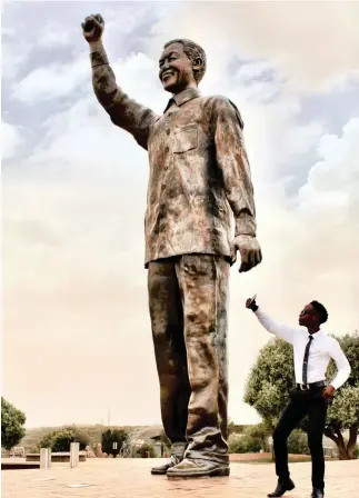  ??  ?? THULANE Mashiya with the 6.5m-high bronze statue of Nelson Mandela on Naval Hill. | BIANCA COLEMAN