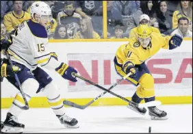  ?? AP PHOTO ?? Eeli Tolvanen, right, of the Nashville Predators, reaches for the puck against Jack Eichel of the Buffalo Sabres.