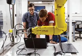  ?? Sam Owens/Staff photograph­er ?? Research engineers David Spielman, left, and Tyler Marr work together to program a robot for a demonstrat­ion project at Southwest Research Institute.