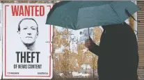  ?? DAVID BLOOM ?? A pedestrian walks past a poster featuring an image criticizin­g Facebook CEO Mark Zuckerberg in Edmonton on June 17.