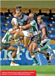  ??  ?? Adeesha Weeratunga (right) and Reyhan Silva cling on to an air borne Hong Kong player