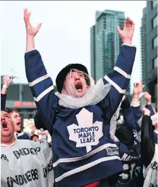  ?? GALIT RODAN/THE CANADIAN PRESS ?? Fans react while watching sports action on large TV screens at Maple Leaf Square in Toronto Wednesday on a night when Toronto FC, the Maple Leafs, Raptors, Blue Jays, and even the AHL Marlies were all in action — with only the Raptors emerging...