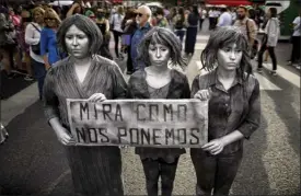  ?? The Associated Press ?? A trio of women hold a sign with a message that reads in Spanish: “See how we end up,” at a demonstrat­ion in Buenos Aires, Argentina, Friday.