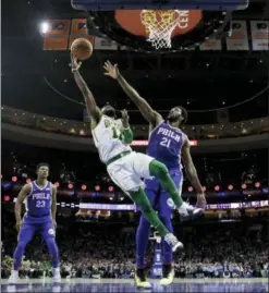  ?? MATT SLOCUM - THE ASSOCIATED PRESS ?? The Boston Celtics’ Kyrie Irving (11) goes up for a shot past Philadelph­ia 76ers’ Joel Embiid (21) during the first half of an NBA game Wednesday, in Philadelph­ia.